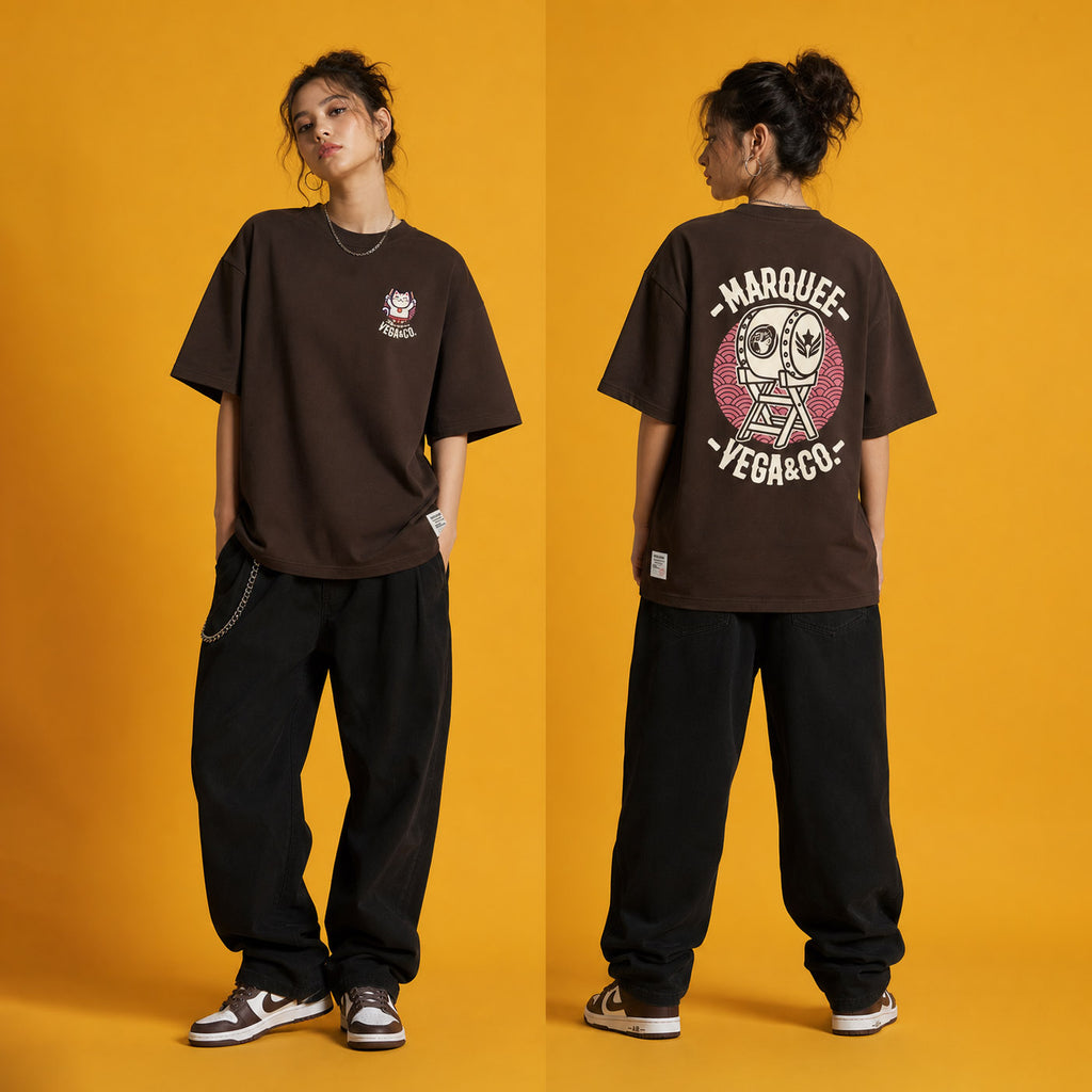 Female model wearing the Lucky Cat Taiko Festival heavyweight loose fit graphic tee in Chocolate, shown front and back.