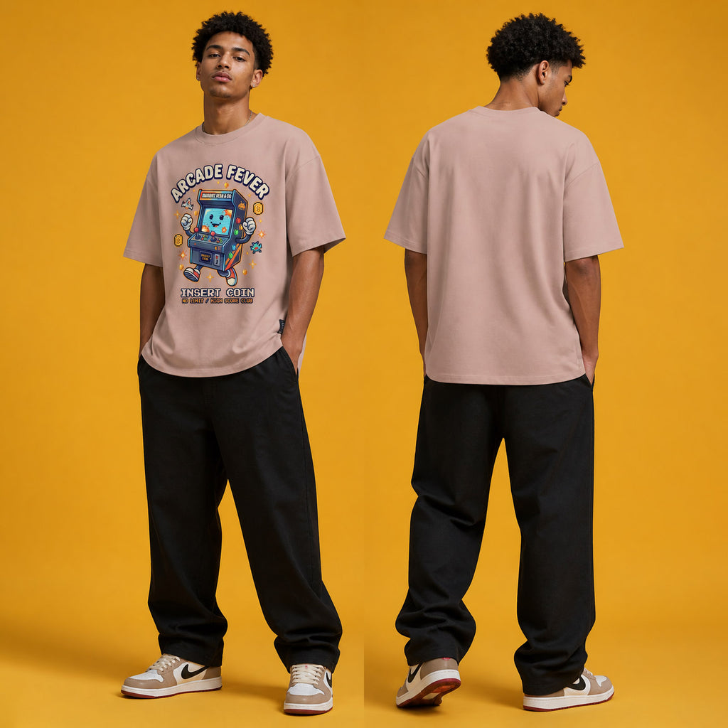 Male model wearing the Arcade Fever Insert Coin heavyweight loose fit graphic tee in Pink, shown front and back.